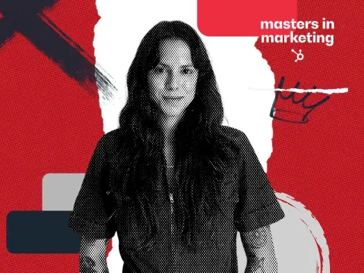 A woman with long dark hair, a short-sleeved shirt, and arm tattoos.